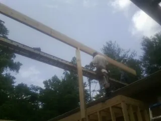 Carpenter setting a ridge beam over a new addition frame — Ice Dam Removal by Roofing Brothers in Clearfield