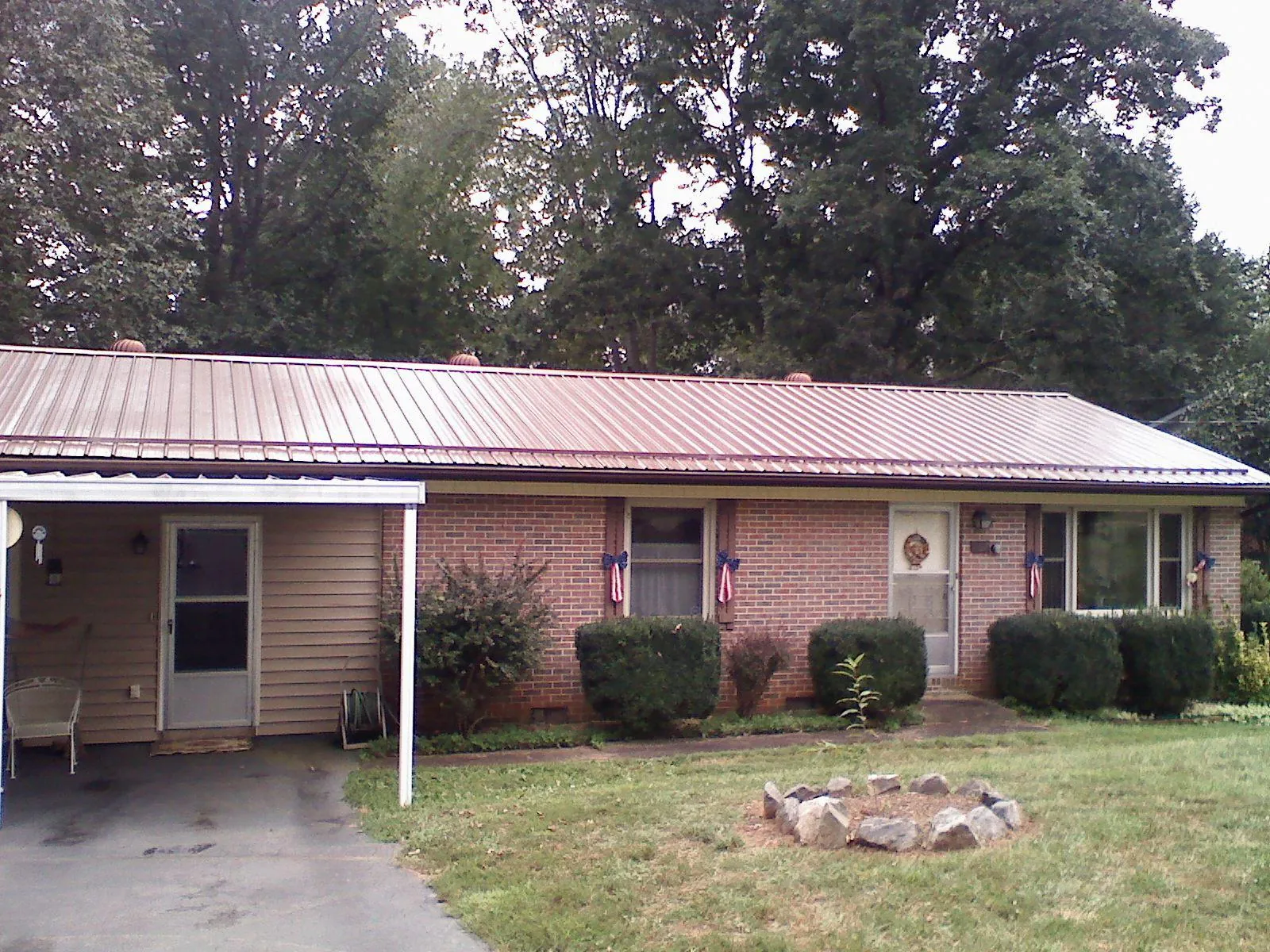 Bronze metal roof and carport on a brick ranch home — Roof Repair work by our crew in Clearfield